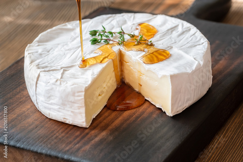 Golden Maple Syrup Pouring Over Camembert Cheese On Rustic Wooden Board Elegantly