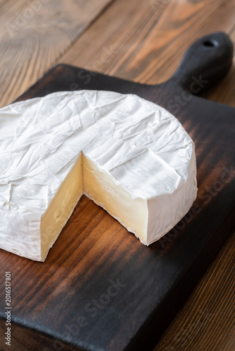 Creamy Camembert Cheese Wheel With Slice Removed On Rustic Wooden Board Display