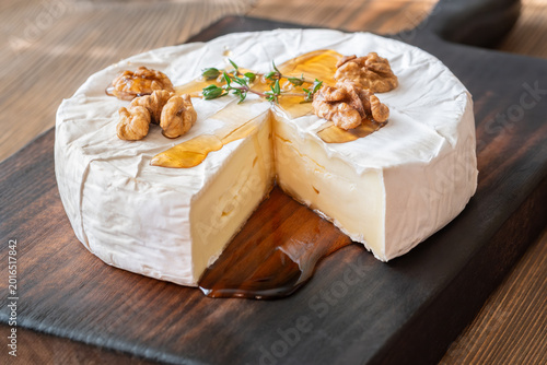 Golden Maple Syrup Pouring Over Camembert Cheese On Rustic Wooden Board Elegantly