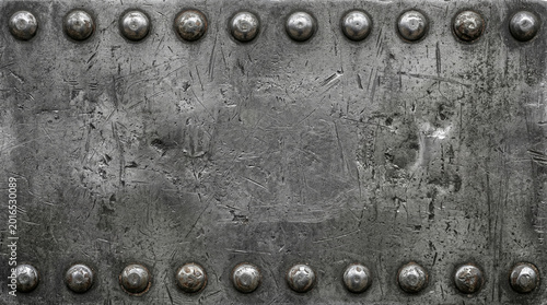 Grunge scratched dark metal plate texture with rivets and bolts on rough steel industrial background