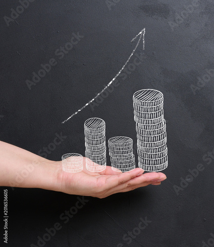 A man's palm holds a stack of coins. Concept of financial growth, investment