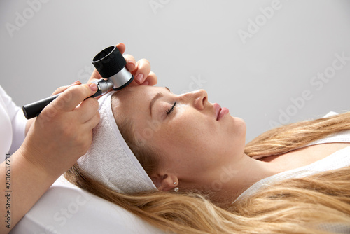 Fotografie Woman gets professional skin exam at doctor's office