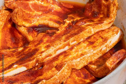 Raw pork belly marinating in spicy red sauce