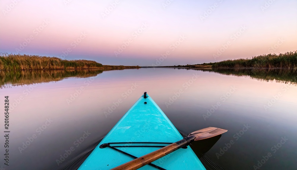 Obraz premium Kayak on calm water at sunset reflecting sky scenery horizon outdoors