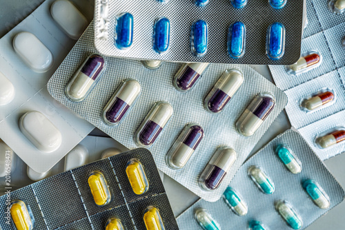 Quadro su tela Overhead view of mixed medication blister packs and colorful capsules