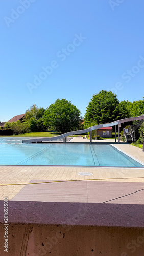 Close-up of infinity pool edge at luxury summer resort opening season with crystal blue water reflecting clear sky, minimalist premium spa architecture, exclusive wellness tourism destination concept