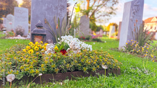 Schilderij op canvas Peaceful cemetery memorial garden during autumn remembrance season with floral g