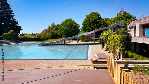 Outdoor luxury resort swimming pool terrace in peak summer holiday season with sun loungers, crystal clear water, modern relaxation deck, premium hotel hospitality area designed for wellness tourism
