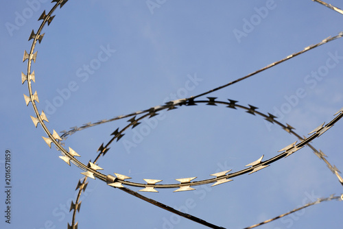 Bild auf Leinwand Sharp Razor Wire Coils Against Clear Blue Sky for Security Concepts