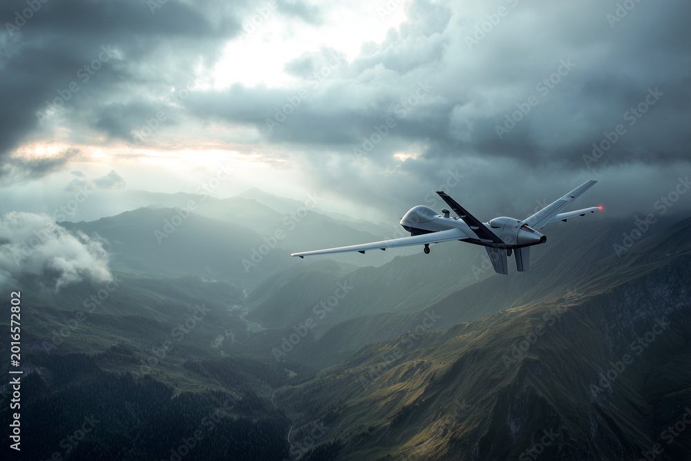 Fototapeta premium Military surveillance drone flying high over a vast mountain range under a dramatic cloudy sky at sunset. Concept of modern aerial reconnaissance and advanced defense technology
