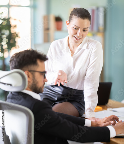 Canvastavla Portrait of adult business couple flirting at table at workplace in office