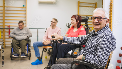 Group of diverse people with disabilities attending a rehabilitation session in a cheerful and inclusive healthcare setting