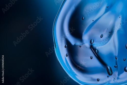 Macro abstract image of dark blue transparent cosmetic gel with bubbles and glossy fluid texture, ideal for skincare, beauty, hydration and science concepts