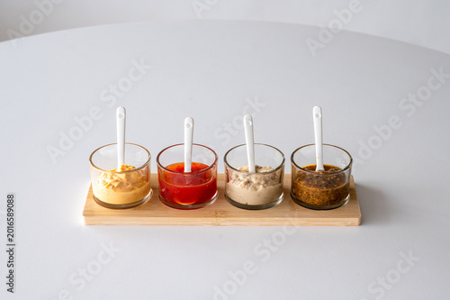 Photos Mustard and dipping sauces row on bamboo board side view