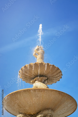 A fountain in Salzburg on a clear day against a blue sky