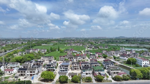 Aerial Rural Village and Farmland Under Cloudy Sky