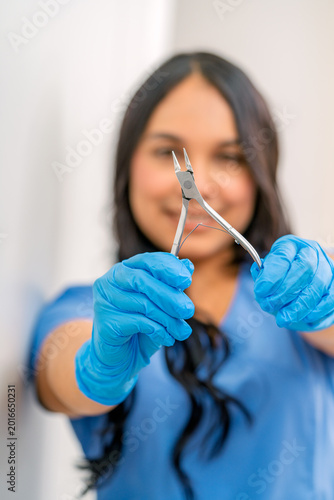 Εκτύπωση καμβά Podiatrist holding pedicure nipper for foot care