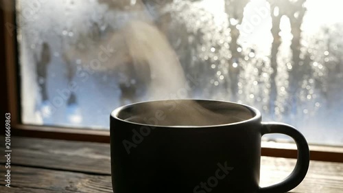 Steaming Coffee Cup Beside Frosty Window Morning Warmth
