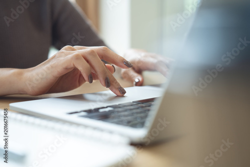 Canvas Print Close up of woman working on laptop, surfing the net, searching the information with notebook on table at home office