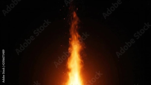 A bright orange flame burns intensely against a dark black background