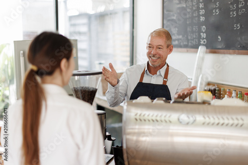 Schilderij op canvas Barista talking to customer at coffee shop counter