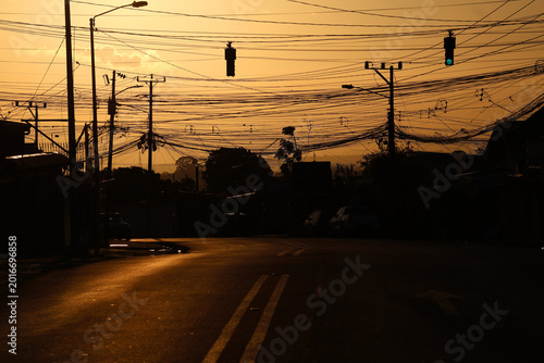 Photos Urban street view with chaotic electrical cables and traffic light at dusk