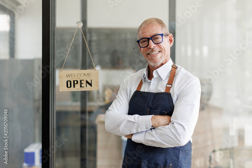 Cuadro en lienzo Senior business owner smiling with open sign in shop