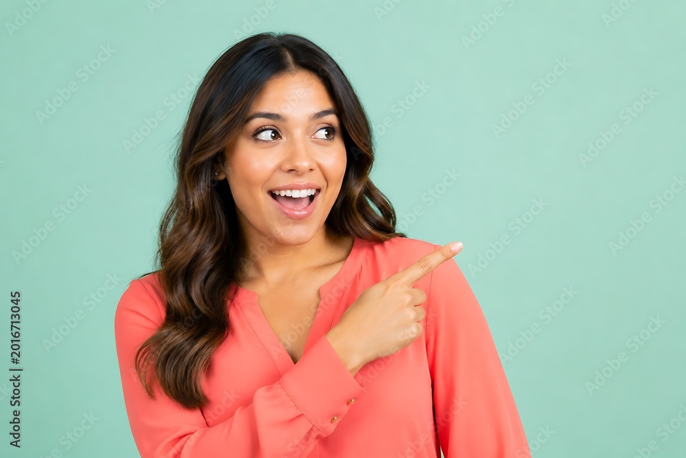 Obraz premium Excited Hispanic Woman Pointing in Pastel Mint Studio