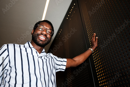 Foto Black man smiling, wearing glasses and striped shirt