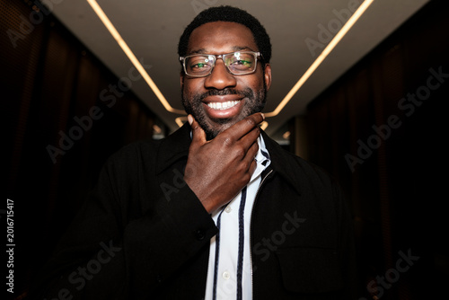 Smiling black man with glasses thinking about future