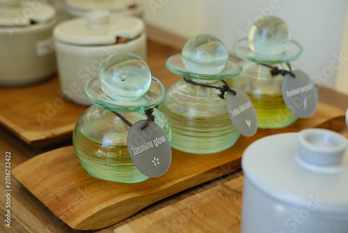 Three Glass Bottles with Massage Oils on Wooden Tray