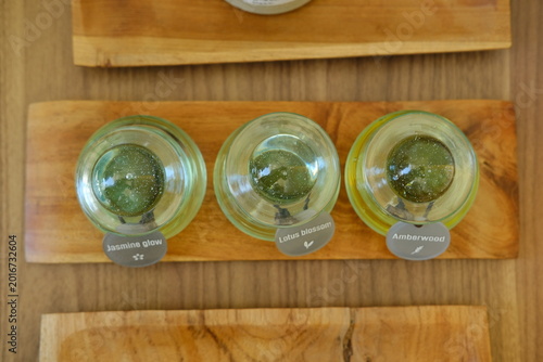 Three Glass Bottles with Massage Oils on Wooden Tray