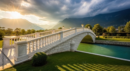 White stone bridge over a canal with mountains in the background
