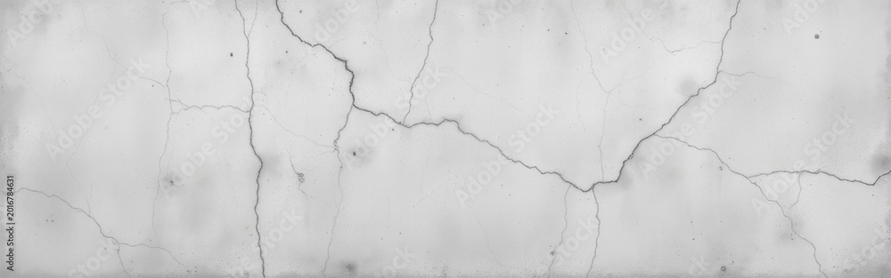 Fototapeta premium Cracked concrete wall with visible lines and texture in grayscale.