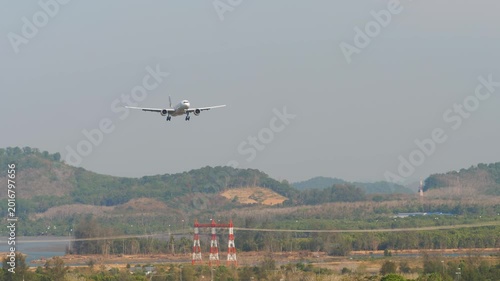 Commercial airplane approaching landing at Phuket airport. Passenger flight arriving. Tourism and travel concept