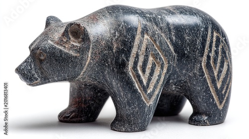Inuit carved soapstone animal sculpture with smooth dark texture, isolated on a white background