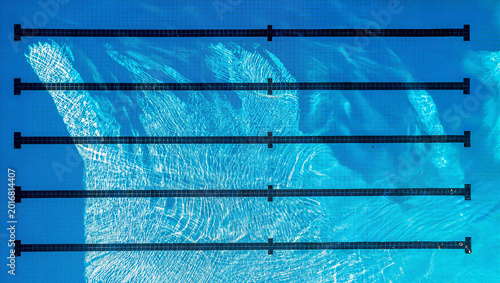 Quadro em tela Aerial top view of empty blue swimming pool with lane lines and clear rippled wa
