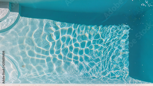 Foto Aerial top view of empty turquoise swimming pool with clear sparkling rippled wa
