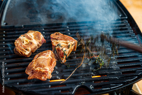 Obraz na płótnie Grilling marinated meat with aromatic herbs on a sunny afternoon at a backyard b