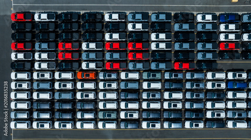 Aerial drone view of thousands of new cars parked at port for global export.