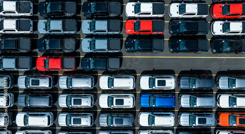 Aerial drone view of thousands of new cars parked at port for global export.