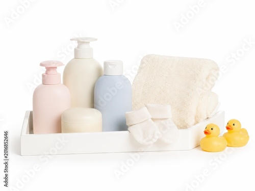 Baby cosmetic spa bath set with frosted bottle cream jar oil towel socks and yellow duck on white background