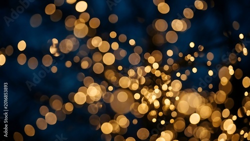 Golden sparkle bokeh lights on dark textured background with abstract background