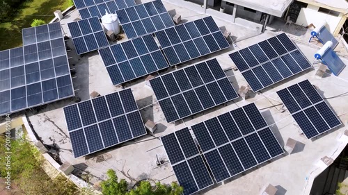 An aerial view of a modern rooftop solar power system installed on a large building. Multiple photovoltaic solar panels are arranged efficiently across the rooftop to generate clean, renewable energy.