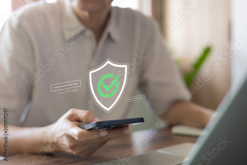 Fotografía Man using smartphone for online banking with glowing security shield and green checkmark hologram
