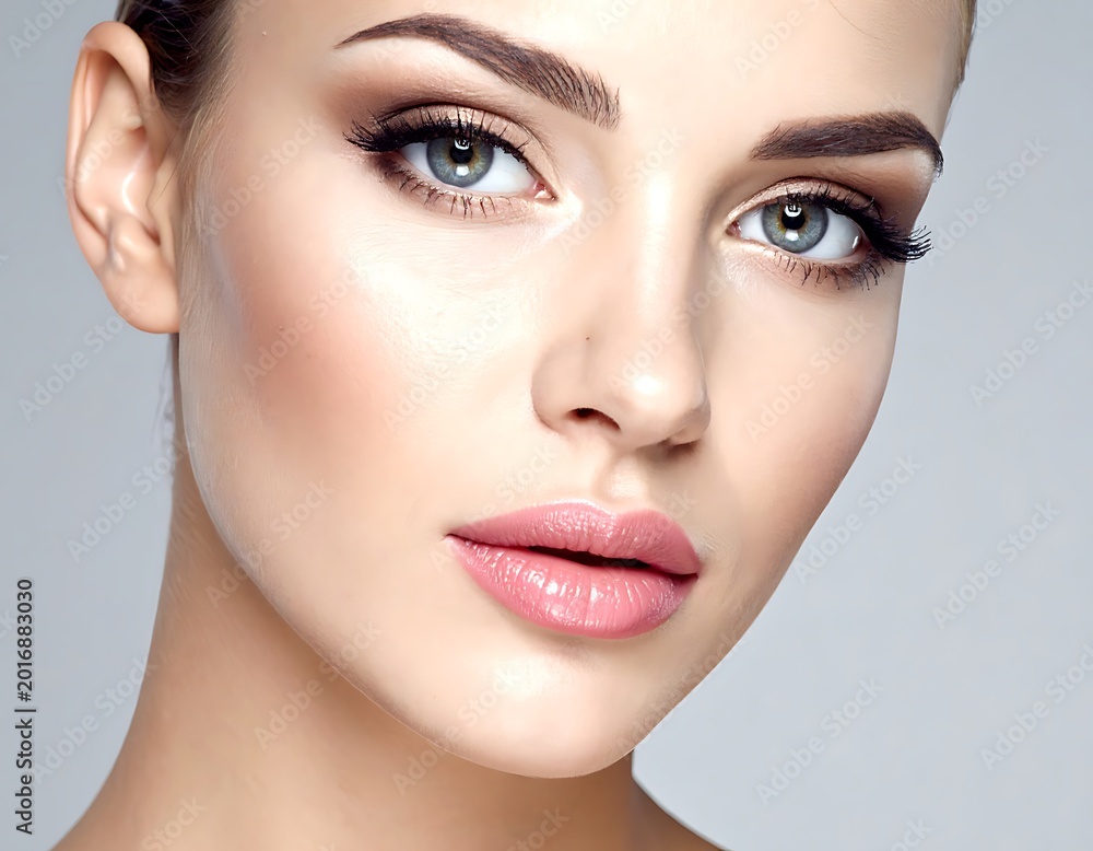 Fototapeta premium A woman's face with subtle makeup and a neutral expression