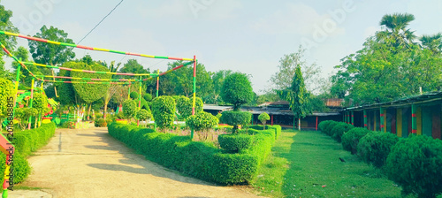 Quadro em tela Scenic park pathway winding through manicured gardens and colorful structures