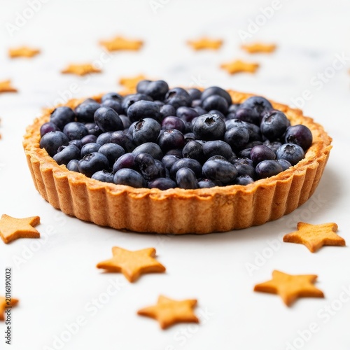 Blueberry Tart Sits on White Surface Surrounded by Star-Shaped Cookies on a S...
