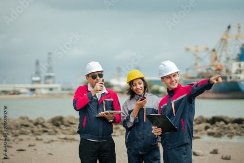 Cuadro en lienzo Harbor engineering crew using radio communication and pointing toward maritime shipping area while managing industrial logistics and operational planning at commercial port