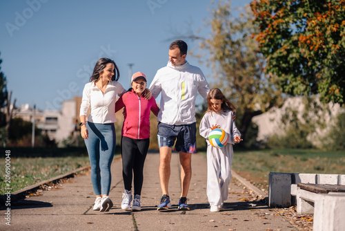 Tableau sur toile Family walking together in park enjoying leisure time